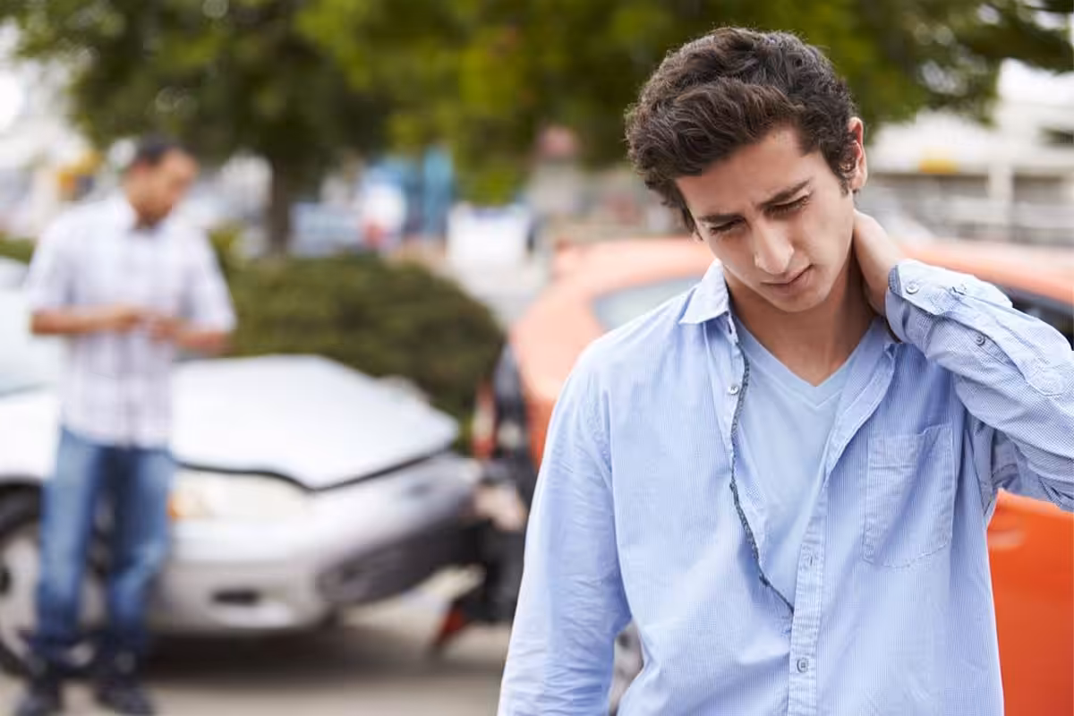 man holding his neck cause by car accident